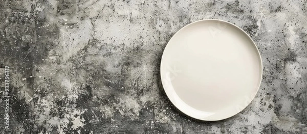 Fototapeta View from above of a blank plate on a concrete surface with copy space image for your design.