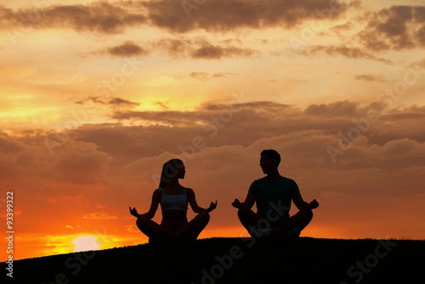 Fototapeta Man and  woman meditating in the mountains. 