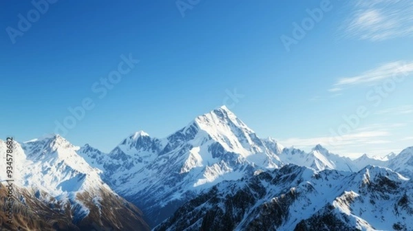 Fototapeta Majestic mountain range with snow-capped peaks and clear blue sky above. Majestic Mountain Range