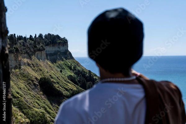 Fototapeta Man in the foreground looking out at a mountainside on the Island of Corfu in Greece.