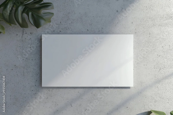 Obraz A white rectangular card mockup, placed on a gray concrete wall, with no text or images on it. Created with AI