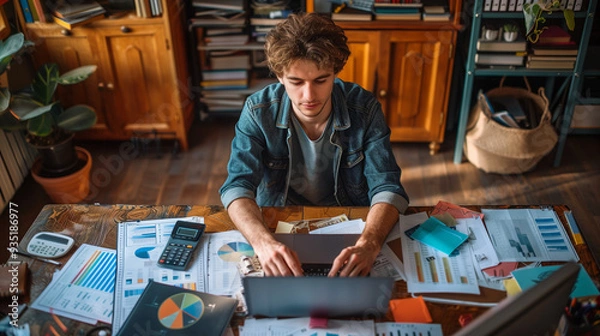 Fototapeta A person sitting at a desk with a laptop, calculator, and financial documents. Budget planning, financial management, personal budgeting, and financial planning concept.