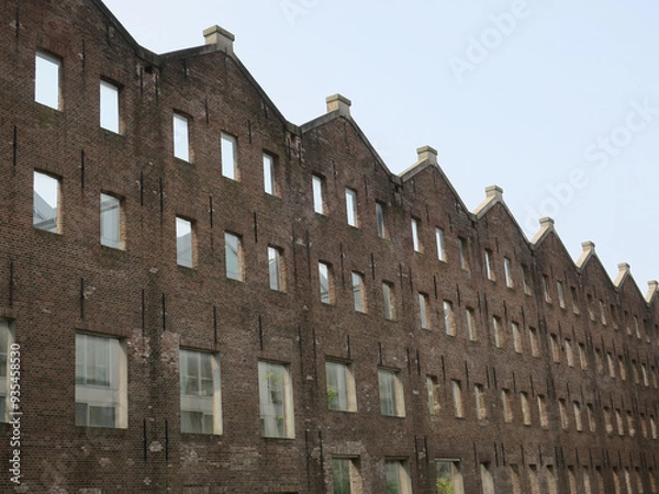 Fototapeta row of facades in brick stones with empty window sills