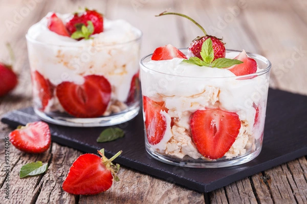 Fototapeta Eton Mess - Strawberries with whipped cream and meringue in a glass beaker. Classic British summer dessert.selective focus