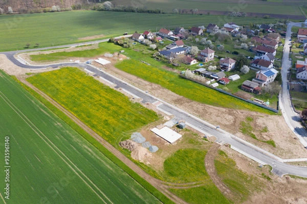 Fototapeta Aerial view of construction site with new roads. Family houses as example of real estate development in suburbs.  Construction of residential houses in the microdistricts. Space for text. Cityscape