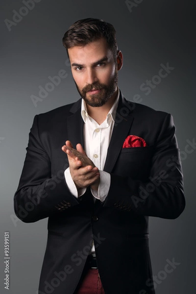 Obraz Man's style. Elegant young man in a suit posing. Studio shot.