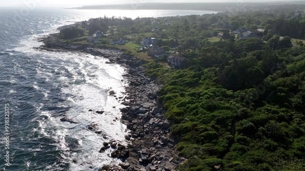 Fototapeta Ocean waves and surf breaking on peaceful rocky coastline  beach as sunshine reflects on water during summertime along seashore in Maine