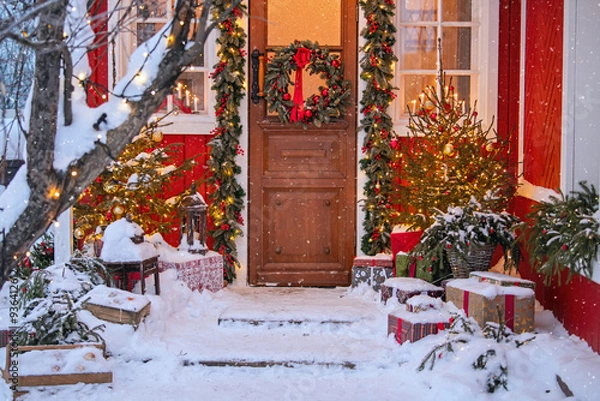 Obraz Attractive Christmas entrance decorated with wreath and garlands with snow on the porch.