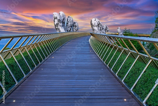 Obraz View of the Golden Bridge being raised by two giant hands on Ba Na Hill at sunrise, Danang, Vietnam.