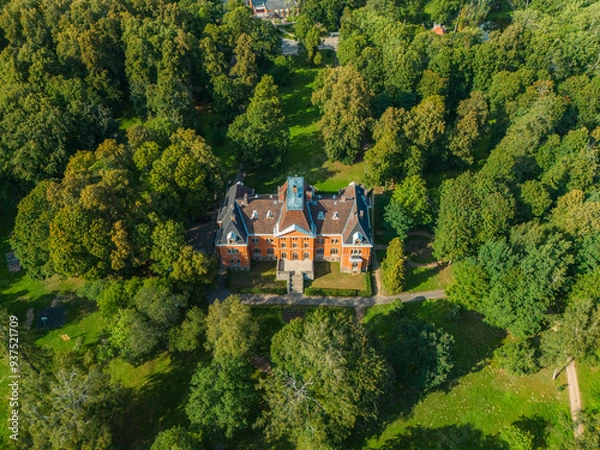 Fototapeta An old castle in the middle in the park. Old manor from drone view