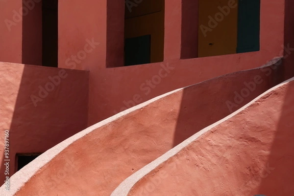 Obraz Vue d'un détail de l'escalier de couleur orangée de la maison des esclaves de l'île de Gorée au Sénégal. Rampe de forme incurvée. Architecture coloniale. Bâtiment rénové et coloré. Avril 2024.