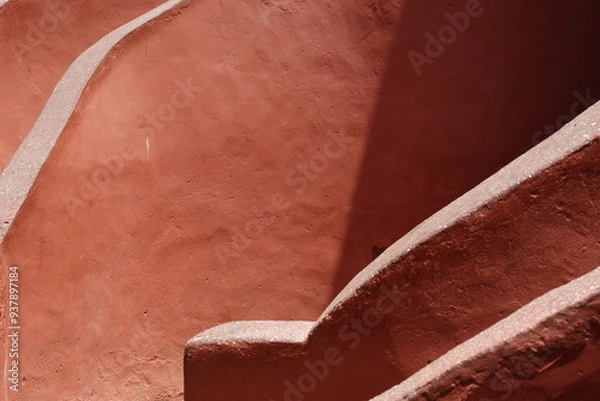 Obraz Vue d'un détail de l'escalier de couleur orangée de la maison des esclaves de l'île de Gorée au Sénégal. Rampe de forme incurvée. Architecture coloniale. Bâtiment rénové et coloré. Avril 2024.
