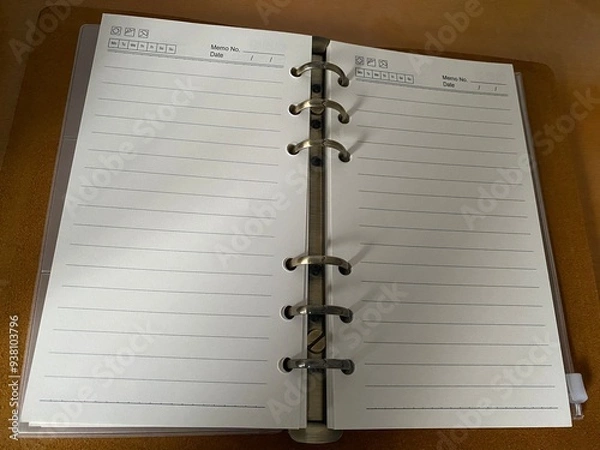 Fototapeta opened notebook planner  with 6 rings on a wooden table