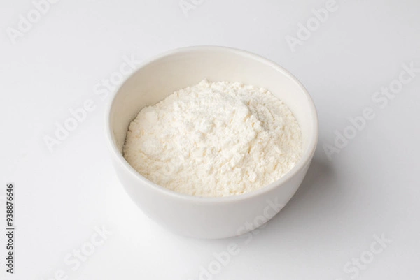Fototapeta Bowl of white cornstarch on a plain background, essential ingredient for baking and cooking during holiday season