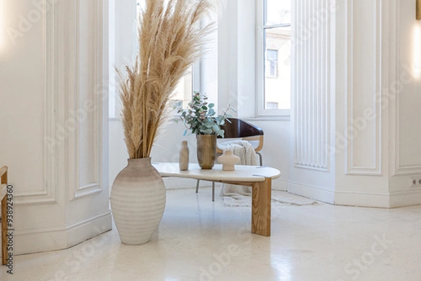 Obraz bright interior design of spacious living room with white walls and decorative unique historical moldings on ceiling stylish modern furniture in warm colors without people daylight through the windows