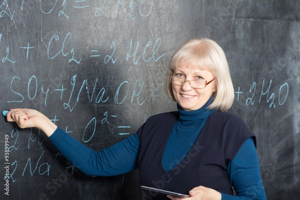 Fototapeta Teacher showing formulas on the blackboard
