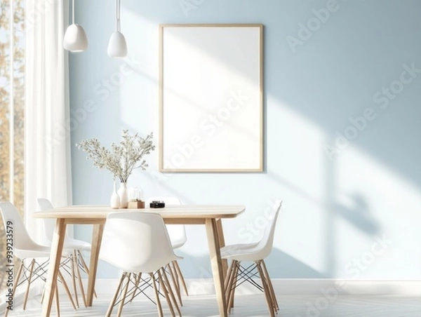 Fototapeta A white framed picture hangs on a wall above a wooden dining table