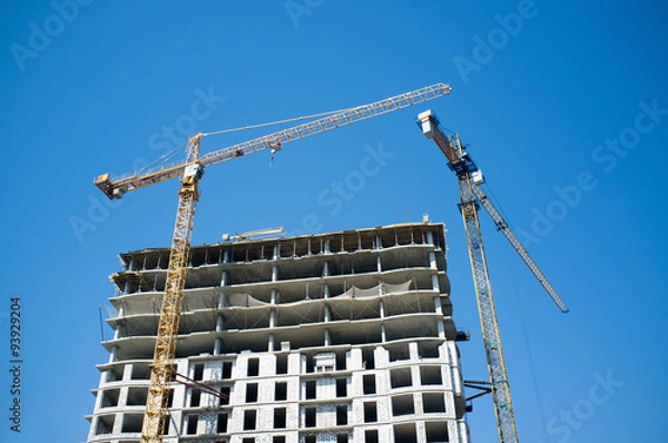 Fototapeta Crane at a construction site against the sky