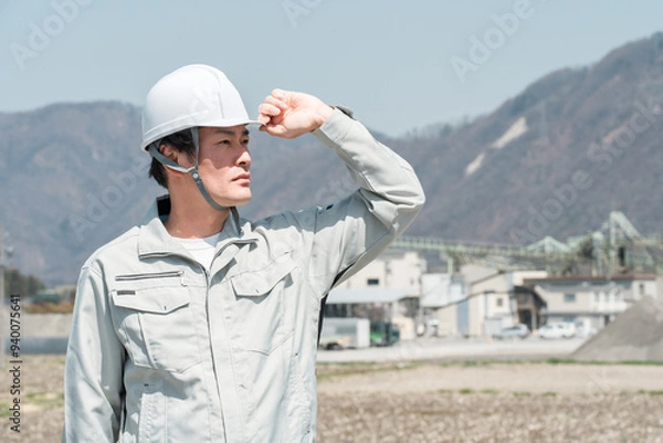 Fototapeta ヘルメットを被った作業着姿のアジア人男性作業員
