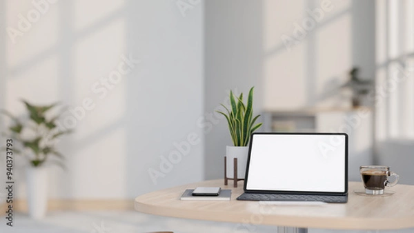 Fototapeta A digital tablet mockup and a wireless keyboard on a wooden table in a minimalist white room.