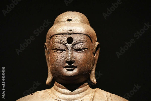 Obraz Close up Buddha face statue isolated on black background. Bronze Buddha statue portrait.