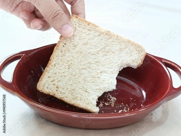 Obraz hand holding Wholemeal bread in ceramic bowl