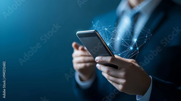 Obraz Businessman's hand using smartphone with network connection on blue background. Technology concept