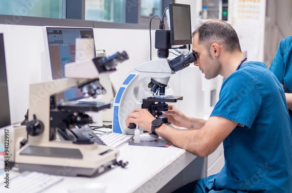 Obraz Veterinarian examining samples under a microscope in a lab
