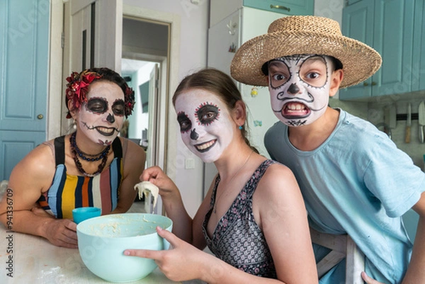 Fototapeta mother and children prepare bread of the dead for the holiday, day of the dead in mexico, halloween, family having fun and baking pies, dough, flour, buns, hands,