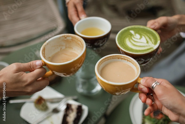 Fototapeta Four friends gather for breakfast in a cozy cafe enjoying buckwheat tea, cappuccino, matcha latte.