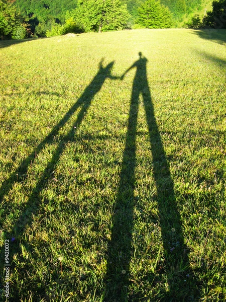 Fototapeta Man and child silhouettes at afternoon sun beams