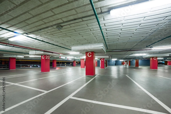 Obraz empty grey parking with colored red columns without cars