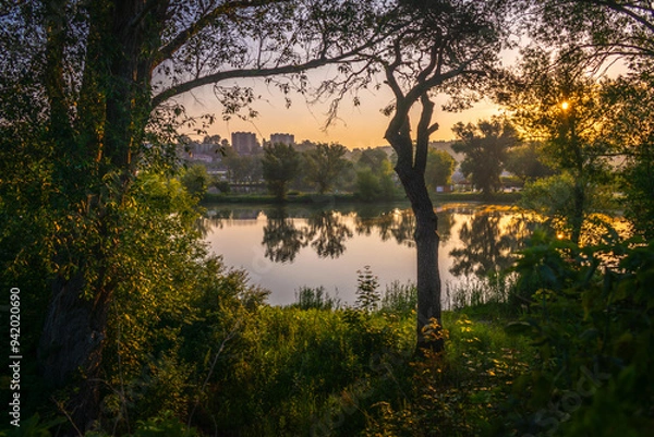 Fototapeta Wschód słońca nad jeziorem wśród zieleni i drzew
