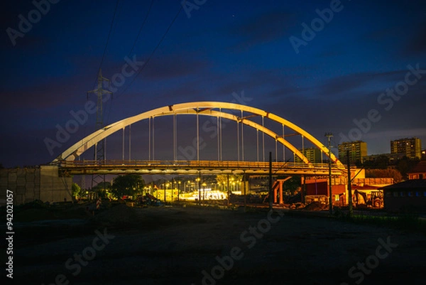 Fototapeta Nowoczesny most łukowy oświetlony nocą na tle ciemnego nieba