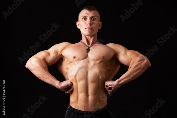 Obraz bodybuilder with pumped the chest on a black background