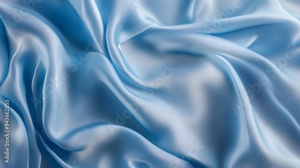 Fototapeta Close-up of light blue satin fabric with soft, flowing folds, showcasing its smooth texture and elegant, glossy finish.
