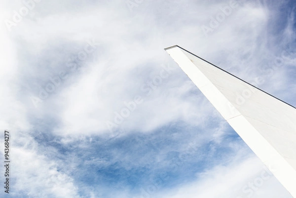 Fototapeta Abstrakte Betonwand in weiß. Architektur vor blauem Himmel. 
Abstract concrete wall in white. Architecture in front of blue sky.