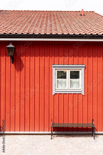Fototapeta Skandinavische Architektur. Rote Hausfassade mit kleinem weißem Fenster. 
Scandinavian architecture. Red house facade with small white window. 