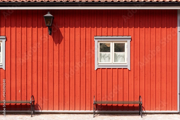 Fototapeta Rote Hausfassade mit kleinem weißem Fenster. Skandinavische Architektur. Red house facade with small white window. Scandinavian architecture.