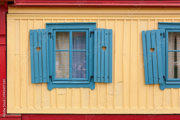 Fototapeta Schiefe blaue Fenster. Lustige Architektur. Herz in Fensterladen. Crooked blue windows. Funny architecture. Heart in shutter.