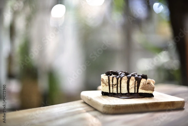 Fototapeta Cream cake with cookies and chocolate syrup on top