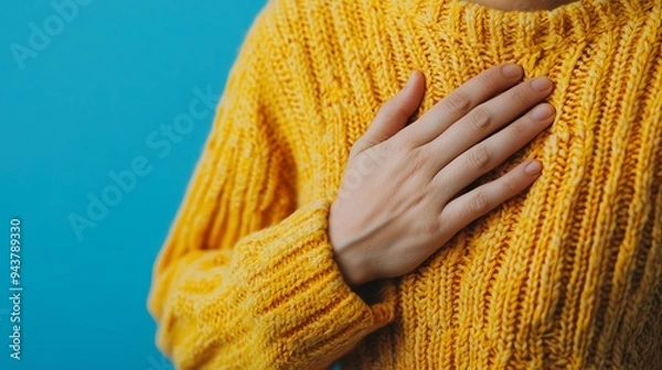 Fototapeta Closeup of a persons hand clutching their chest, emphasizing intense heart pain and suffering, cardiac emergency