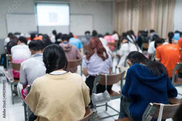 Fototapeta Selective focused high school or university students are intently writing on their answer sheets during a final exam in the classroom.