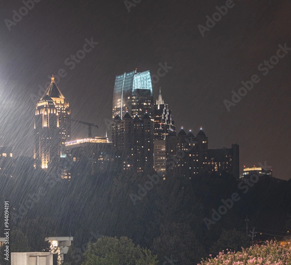 Fototapeta Skyline Cityscape showing office buildings,  condos, and hotels at night during a rain storm.