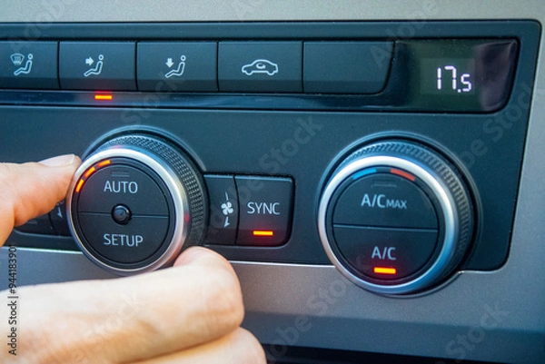 Obraz Set up air conditioner in the car. Hand turns air conditioner ring. Display indicates 17.5 degree celsius temperature inside the car. Cooling air in the car
