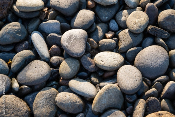 Fototapeta A pile of rocks with a few large ones in the middle. The rocks are grey and black
