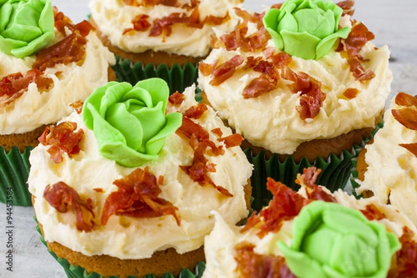 Fototapeta Cupcakes cabbage and bacon shot close-up front on at an angle on white wooden boards landscape