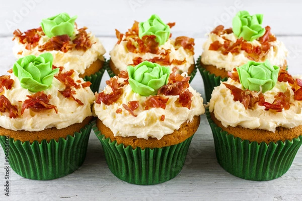 Fototapeta Cupcakes cabbage and bacon shot front on at an angle on white wooden boards landscape