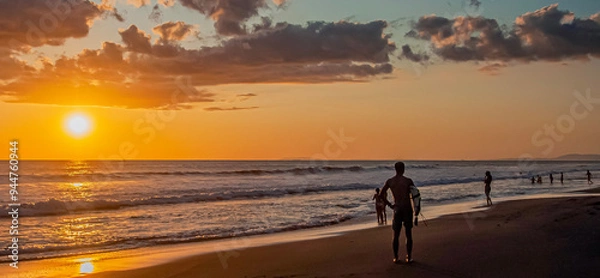 Obraz Unknown man with surfboard on the beach at sunset