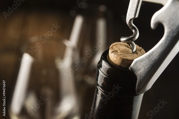 Fototapeta Opening wine bottle with a corkscrew